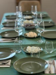 una mesa verde con platos y copas de vino. en Villa Rusi, 