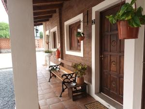 un portico con una porta di legno e due panchine di El Descanso Cafayate a Cafayate