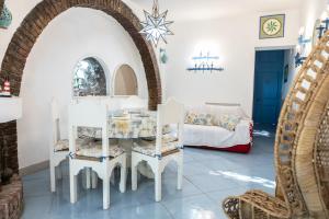 een woonkamer met een tafel, stoelen en een bank bij Villa Daniela Vista Mare - 70metri dalla Spiaggia - WiFi - Free Parking in Terracina