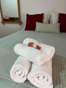 a pile of towels sitting on top of a bed at Apartamentos da Jo in Camanducaia