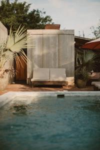 a swimming pool with a white couch next to a swimming pool at Surf Retreat La Saladita, Yoga, Pool, Templo, Casita Sol in La Majahua
