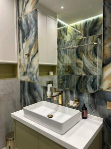 un bagno con un lavandino bianco e uno specchio di NestOne - Apartment hotels a Tashkent