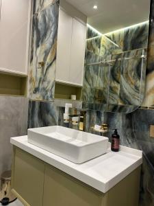 bagno con lavandino bianco e parete di NestOne - Apartment hotels a Tashkent Altre 80 foto