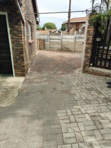 eine gemauerte Auffahrt mit einem Tor und einem Gebäude in der Unterkunft Tranquil Leisure in Midrand