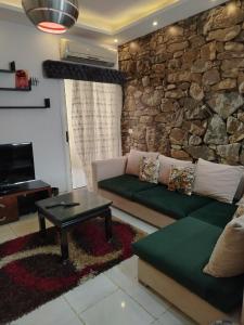 赫尔格达Paradise Hill Compound的带沙发和石墙的客厅