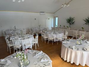 una stanza piena di tavoli e sedie con tovaglie bianche di Green Gold Passion a Santo Estêvão