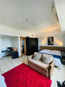 Un dormitorio con una cama y un sofá en una habitación. en Tropical Executive Flat Vista Maravilhosa do Rio, en Manaus