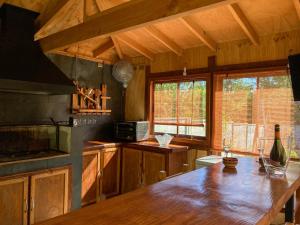 a kitchen with a wooden table in a room at CABAÑAS RACO in Licán Ray
