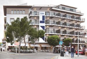 a large white building with balconies on a street at Hotel Eolo in Port de Pollensa
