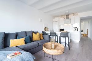a living room with a blue couch and a kitchen at Casa Tabera - Sun Club Playa del Águila in Playa del Aguila