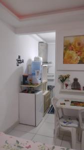 a white kitchen with a table and a table and a chair at Suíte com a melhor vista de Manaus in Manaus