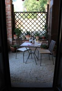 a table and chairs on a patio with a fence at Dimora al Castello in Govone