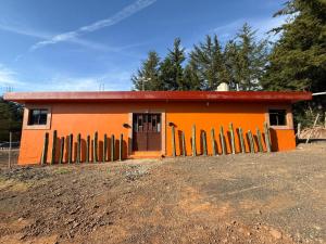 a small orange house with a fence in front of it at Casa Terral in Balastre Rojo