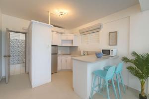 Una cocina con encimera y dos taburetes azules. en Beachfront Studio in Aguada, en Aguada
