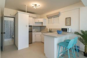 Una cocina con encimera y dos taburetes azules. en Beachfront Studio in Aguada, en Aguada