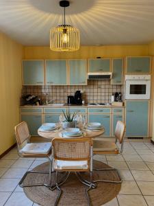 eine Küche mit einem Tisch und Stühlen in einer Küche in der Unterkunft Domaine Wagenbourg à Soultzmatt in Soultzmatt