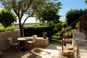 Un patio con una mesa y sillas y un árbol. en Gite Domaine De La Bruge, en Saint-Remèze