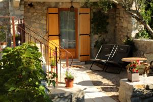 un patio con una puerta de madera y una mesa en Gite Domaine De La Bruge, en Saint-Remèze 5 fotos más