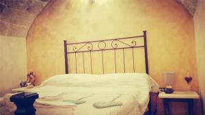ポリニャーノ・ア・マーレにあるSuite Lady Homeのベッドルーム1室(白いシーツとタオル付きのベッド1台付)