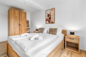 a large white bed in a bedroom with a wooden cabinet at TM Stays - NIVIS - Gemütliches Apartment mit Terrasse & Garten - Ruhe, Natur, Wandern, Ski in Medebach