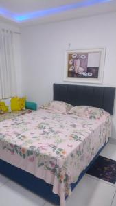 a bedroom with a bed with a floral bedspread at Suíte com a melhor vista de Manaus in Manaus +9 photos