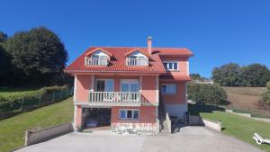 a pink house with a balcony on top of it at CASA FONTE DA PEDREIRA in Sada