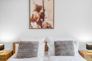 a bedroom with a white bed with two pillows at TM Stays - NIVIS - Gemütliches Apartment mit Terrasse & Garten - Ruhe, Natur, Wandern, Ski in Medebach +16 photos