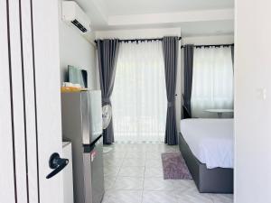 a hotel room with a bed and a window at Sarona House 3 in Ban Thalat Choeng Thale