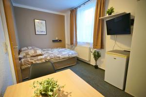 a hotel room with a bed and a table and a desk at die GastHütte in Eisenhüttenstadt +21 photos