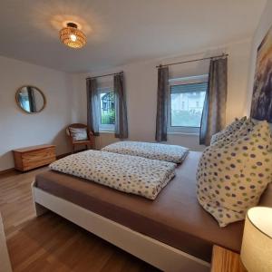 a bedroom with two beds and two windows at Ferienwohnung Gartenblick in Eslohe