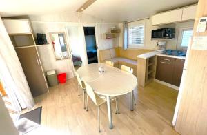 a small kitchen with a table and chairs in a caravan at Premi Home XL SUPERieur 6P 3ch-Puy duFou 25min in La Boissière-de-Montaigu