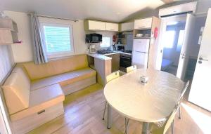 a small kitchen with a table and a dining room at Premi Home XL SUPERieur 6P 3ch-Puy duFou 25min in La Boissière-de-Montaigu