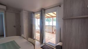 a bedroom with a large sliding glass door to a deck at Premi Home XL SUPERieur 6P 3ch-Puy duFou 25min in La Boissière-de-Montaigu