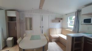 a small living room with a table and a couch at Premi Home XL SUPERieur 6P 3ch-Puy duFou 25min in La Boissière-de-Montaigu