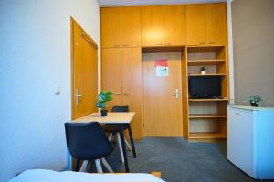 a room with a desk and a table and a tv at die GastHütte in Eisenhüttenstadt