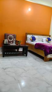 ein Schlafzimmer mit einem Bett und einem Couchtisch in der Unterkunft Sri Narayan Home Stay in Ayodhya