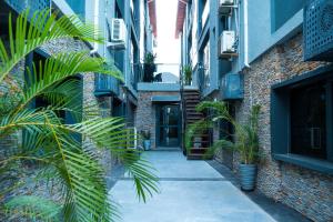 an alley with palm trees in a building at Main Avenue Residence Lagos in Lagos