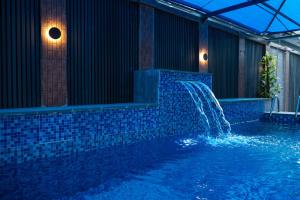 a swimming pool with a fountain in a building at Main Avenue Residence Lagos in Lagos