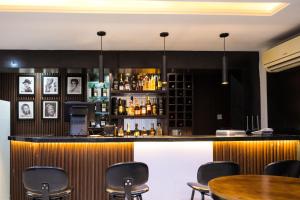 a bar in a restaurant with black walls and chairs at Main Avenue Residence Lagos in Lagos