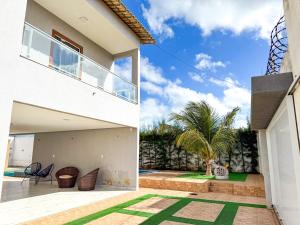 a house with a view of the backyard and a patio at Eficiência - Casa Recanto dos Ventos in Camocim