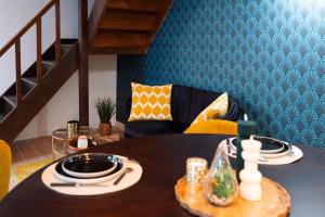 a dining room with a table and a couch at l'écrin du désir in Capestang