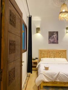 ein Schlafzimmer mit einem Bett und einer großen Holztür in der Unterkunft Palais Taroudant in Taroudant