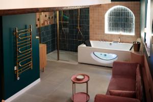 a bathroom with a tub and a toilet and a stool at l'écrin du désir in Capestang
