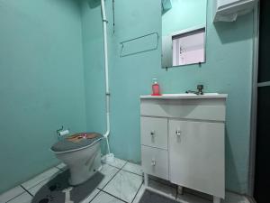een badkamer met een toilet, een wastafel en een spiegel bij Estudio prático e acolhedor , sua base em Floripa in São José