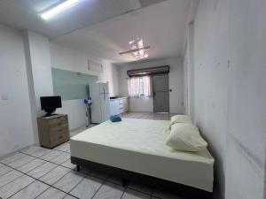 een witte kamer met een bed en een keuken bij Estudio prático e acolhedor , sua base em Floripa in São José