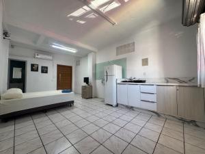 een kamer met een keuken met een koelkast en een tafel bij Estudio prático e acolhedor , sua base em Floripa in São José