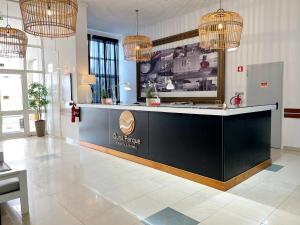 a lobby with a black counter and pendant lights at Bulldog Inn - Duna Parque Group in Vila Nova de Milfontes