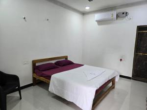 een slaapkamer met een bed en een stoel erin bij Coastal Konkan in Malvan