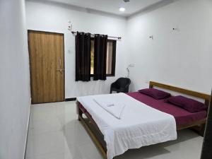 een slaapkamer met een bed en een houten deur bij Coastal Konkan in Malvan