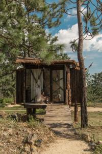 a tree house with a woman sitting in a hammock at Very Muy Epico in San Lucas del Pulque +42 photos